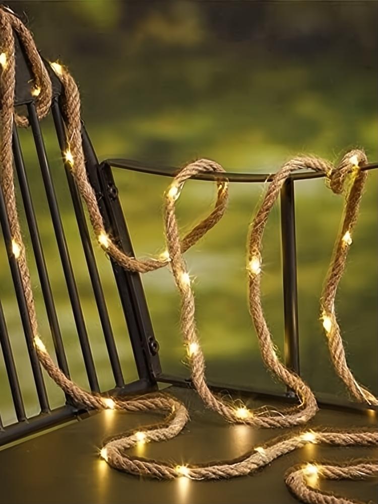 Solar rope light with natural jute finish and warm steady glow, draped on a dark metal chair.