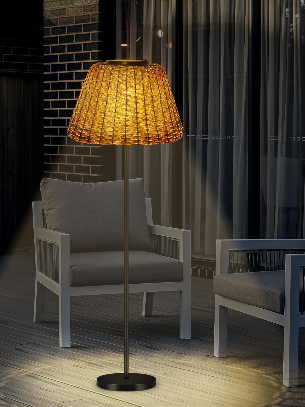 Lámpara de pie LED de mimbre con luz cálida, ideal para exteriores protegidos.