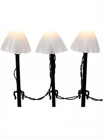 Tres estacas de luz LED blanco cálido con pantallas blancas y bases negras para jardín.