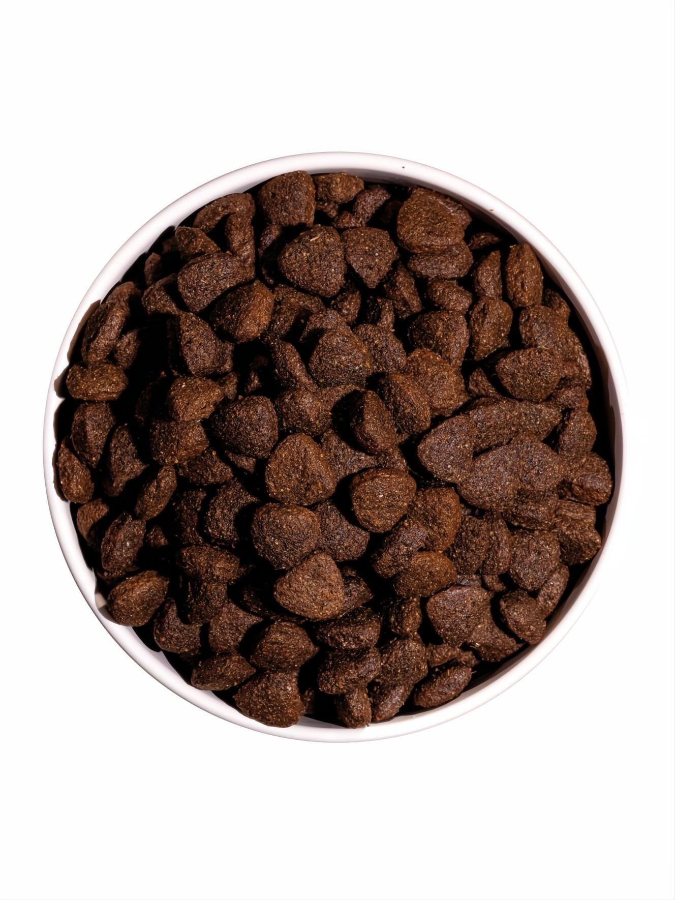 Ownat Classic Lamb & Rice pienso para perros, croquetas marrones en un cuenco blanco.